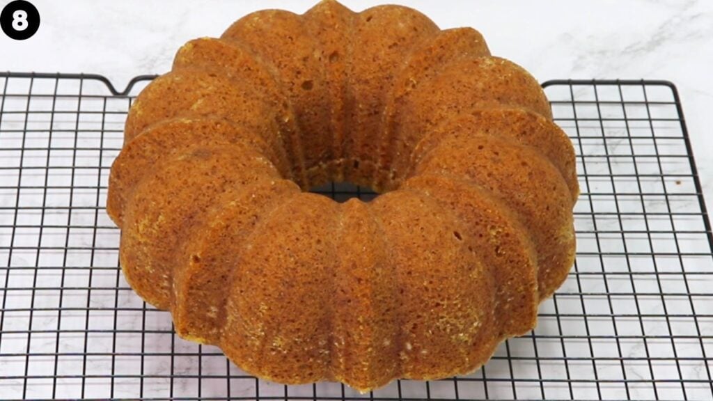 pumpkin bundt cake - Cakes by MK Golden-brown bundt cake on a black cooling rack, viewed from above.